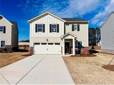 Charming two-story home with attached garage, neutral siding, and classic architectural details at 7722 Sudbury Cir, Covington, GA 30014