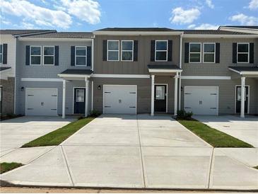 Charming townhouse featuring a one car garage and inviting entrance at 8656 Webb Rd, Riverdale, GA 30274