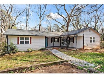 Charming single-story home featuring white siding, dark roof, and a welcoming front porch at 2255 Hunt Rd, Douglasville, GA 30135