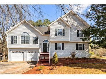 Charming two-story home featuring a two-car garage, arched entry, and manicured front yard at 13 Greystone Nw Ln, Cartersville, GA 30121