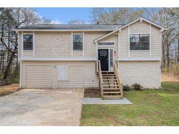 Charming two-story home with a stone foundation, tan siding, and a neatly landscaped front yard at 3875 Mcgill Way, Decatur, GA 30034