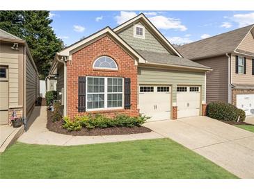 Charming home featuring a brick facade, two-car garage, and well-maintained lawn at 404 Paperbark Ct, Acworth, GA 30102