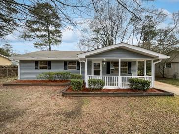 Charming single-story home featuring a welcoming front porch and well-maintained landscaping at 6518 Voyles Dr, Riverdale, GA 30274