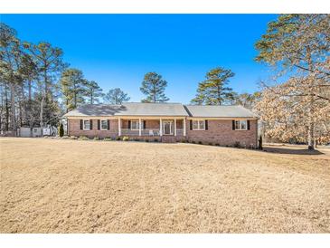 Charming single-story brick home with a manicured front yard and a welcoming front porch at 345 Wedgefield Dr, Mcdonough, GA 30252