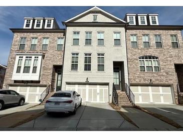 Charming townhome with brick elevation, two-car garage and neatly maintained landscaping at 1411 Wisteria Wall Dr, Suwanee, GA 30024