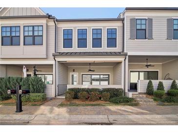 Charming townhome features a covered porch, manicured landscaping, and inviting curb appeal at 671 Stickley Oak Way, Woodstock, GA 30189