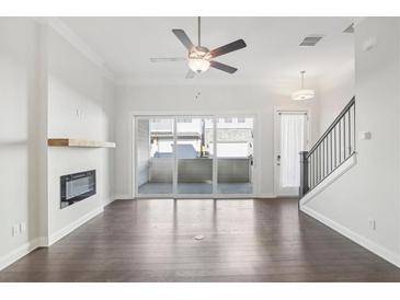 Bright living room featuring a ceiling fan, modern fireplace, and sliding glass doors to a patio at 671 Stickley Oak Way, Woodstock, GA 30189