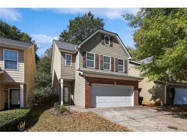 Charming two-story home with neutral siding, brick accents, and an attached two-car garage at 2157 Capella Sw Cir, Atlanta, GA 30331