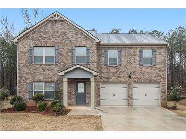 Charming brick home with a two-car garage and a well-maintained front yard at 11930 Guelph Cir, Hampton, GA 30228
