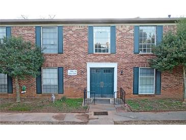 Brick apartment building featuring blue doors and shutters plus well-maintained landscaping at 5586 Kingsport Dr, Atlanta, GA 30342