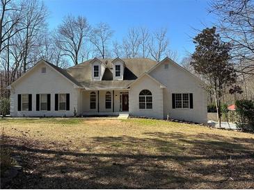 Charming painted brick home with manicured lawn, dormer windows and inviting front entry at 384 Minix Rd, Sharpsburg, GA 30277