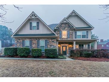 Charming two-story home with a stone and siding facade, manicured bushes, and a well-kept front yard at 4719 Joseph Eli Dr, Snellville, GA 30039