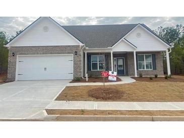 Charming single-story home with brick facade, attached garage, and well-maintained front yard at 815 Crossroads Ct, Social Circle, GA 30025