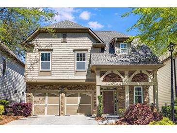 Charming two-story home with stone accents, a two-car garage, and beautifully landscaped front yard at 11894 Aspen Forest Dr, Johns Creek, GA 30005