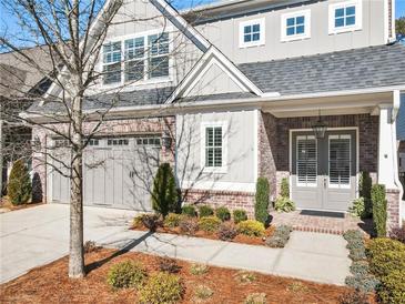 Charming two-story home with a brick and gray exterior, landscaped front yard, and attached two-car garage at 105 Ivey Way, Woodstock, GA 30188