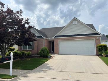 Charming brick home featuring a two-car garage and a well-maintained front yard at 710 Village Ln, Loganville, GA 30052
