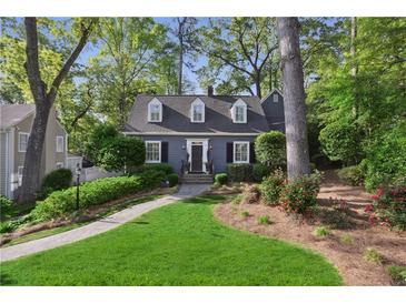 Charming two-story home featuring lush landscaping and a welcoming walkway leading to the front entrance at 560 Collier Nw Rd, Atlanta, GA 30318