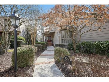 Charming home featuring a well-manicured front yard with mature trees and a welcoming walkway at 4084 Columns Dr, Marietta, GA 30067