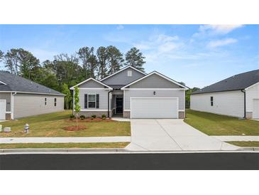 Charming single-story home with a two-car garage, well-manicured lawn, and welcoming front entrance at 8601 Secretariat Dr, Lithonia, GA 30058