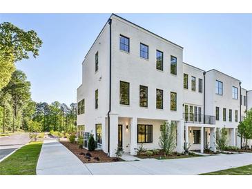 Modern, three-story white brick townhome featuring black-framed windows and manicured landscaping at 2150 Tidwell Ln # 5, Atlanta, GA 30318