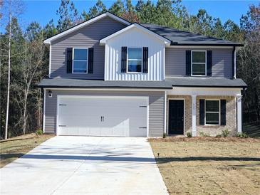 Charming two-story home featuring gray siding, a two-car garage, and a neatly landscaped front yard at 75 Heyman, Covington, GA 30016