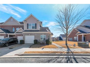 Charming two-story home featuring a neutral brick facade, attached garage, and manicured landscaping at 2555 Flat Shoals Rd # 1705, Atlanta, GA 30349