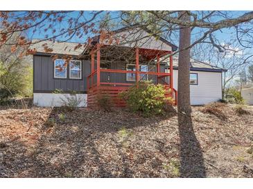 Charming home featuring a covered porch with red accents and a well-maintained yard surrounded by mature trees at 1180 Fleming St, Atlanta, GA 30080