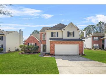 Charming two-story home featuring a brick facade, well-maintained lawn, and an attached two-car garage at 5300 Willow Park Blvd, Atlanta, GA 30349