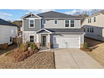 Charming two-story home with a two car garage, stone accents, and a well manicured lawn at 442 Payne Rd, Woodstock, GA 30188