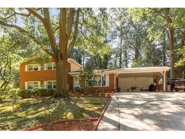 Charming two-story brick home with a covered carport and mature trees in a leafy neighborhood at 1387 John Robert Dr, Morrow, GA 30260