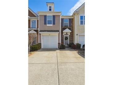 Charming townhome featuring a one-car garage, brick accents, and manicured landscaping at 1914 Lakeshore Overlook Nw Cir, Kennesaw, GA 30152