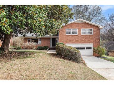 Charming brick home featuring a two-car garage and a well-maintained front yard at 1485 Camelot Ln, Tucker, GA 30084