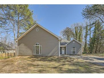 Charming one-story home features neutral siding and a well-maintained lawn on a sunny day at 2985 Pilgrim Mill Rd, Cumming, GA 30041