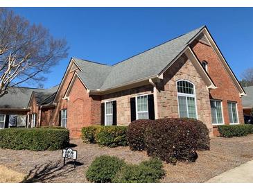 Charming brick and stone home with well-manicured landscaping and a gray shingle roof at 1404 Haven Cir, Douglasville, GA 30135