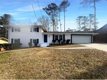 Charming two-story home featuring a white exterior, attached garage, and well-maintained lawn at 1376 Cornwall Rd, Decatur, GA 30032
