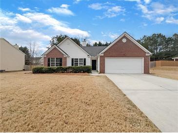 Charming single-story home with a brick and white facade, complemented by a well-manicured lawn at 2545 Lakemeadow Ln, Grayson, GA 30017