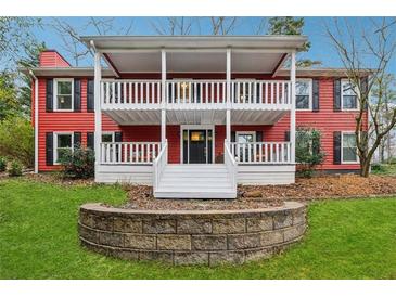 Charming red home with a double-decker covered porch and a landscaped front yard at 605 Jeffrey Ct, Woodstock, GA 30188