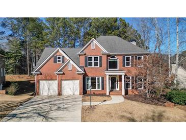Charming two-story brick home with a two-car garage and well-manicured landscaping at 672 Red Sunset Cir, Powder Springs, GA 30127