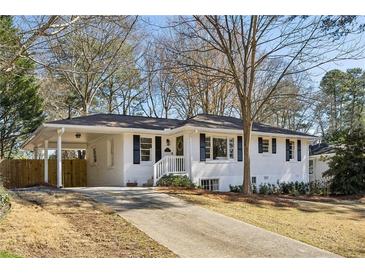 Charming white brick home featuring black shutters, covered parking, and a well-maintained front yard at 2235 Fairway Ne Cir, Brookhaven, GA 30319