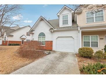 Charming home with brick accents, an attached garage, and well-maintained landscaping at 2414 Clock Face Ct, Lawrenceville, GA 30043