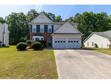 Charming two-story home featuring a well-manicured lawn, brick accents, and a convenient two-car garage at 2535 Fairmont Park Ct, Dacula, GA 30019