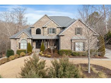 Beautiful brick and stone home with manicured front lawn and mature landscaping at 1355 Cashiers Way, Roswell, GA 30075