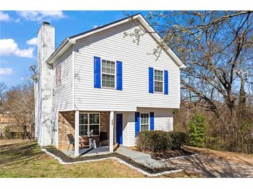 Charming two-story home with white siding and bright blue shutters and a cozy front porch at 392 Fourth St, Forest Park, GA 30297