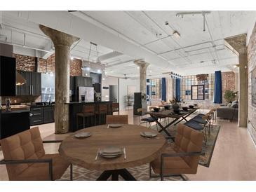 Spacious living room with exposed brick, modern kitchen, dining area, and large windows at 434 Marietta Nw St # 301, Atlanta, GA 30313