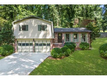 Charming home with a two-car garage, brick and siding accents, and landscaped front yard at 4883 Rock Haven Dr, Lilburn, GA 30047
