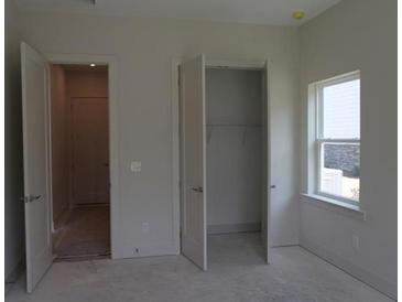 A bedroom features natural light from a window and an open closet at 4780 Briscoe Dr, Cumming, GA 30028