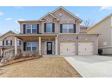 Charming two-story brick home with a two-car garage and covered front porch at 648 Ocean Ave, Canton, GA 30114