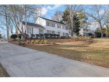 Charming two-story home with white siding, gray shutters, and well-maintained landscaping at 1040 Millridge Se Ln, Marietta, GA 30067