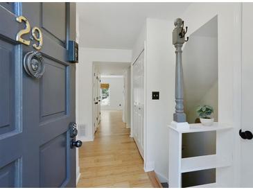 Inviting entryway featuring a wood floor, neutral walls, and a charming front door at 29 Ivy Ne Trl, Atlanta, GA 30342