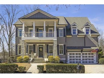 Charming two-story home featuring a welcoming front porch, stone accents, and manicured landscaping at 4815 Westgate Dr, Cumming, GA 30040